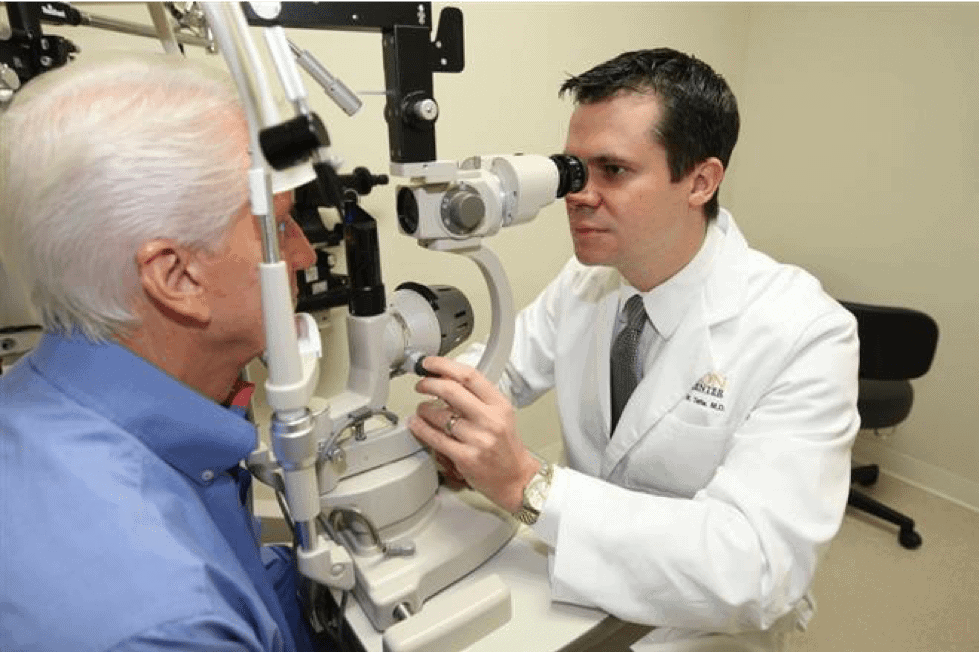 Dr. Stephen M. Tate Performing Eye Exam on an Elderly Man