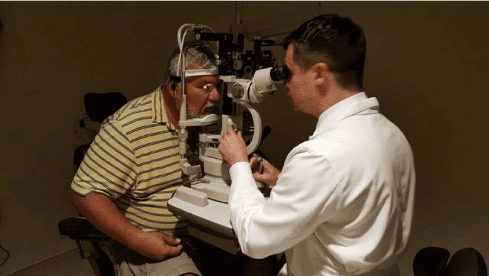 Dr Stephen M. Tate Performing Eye Exam on a Man