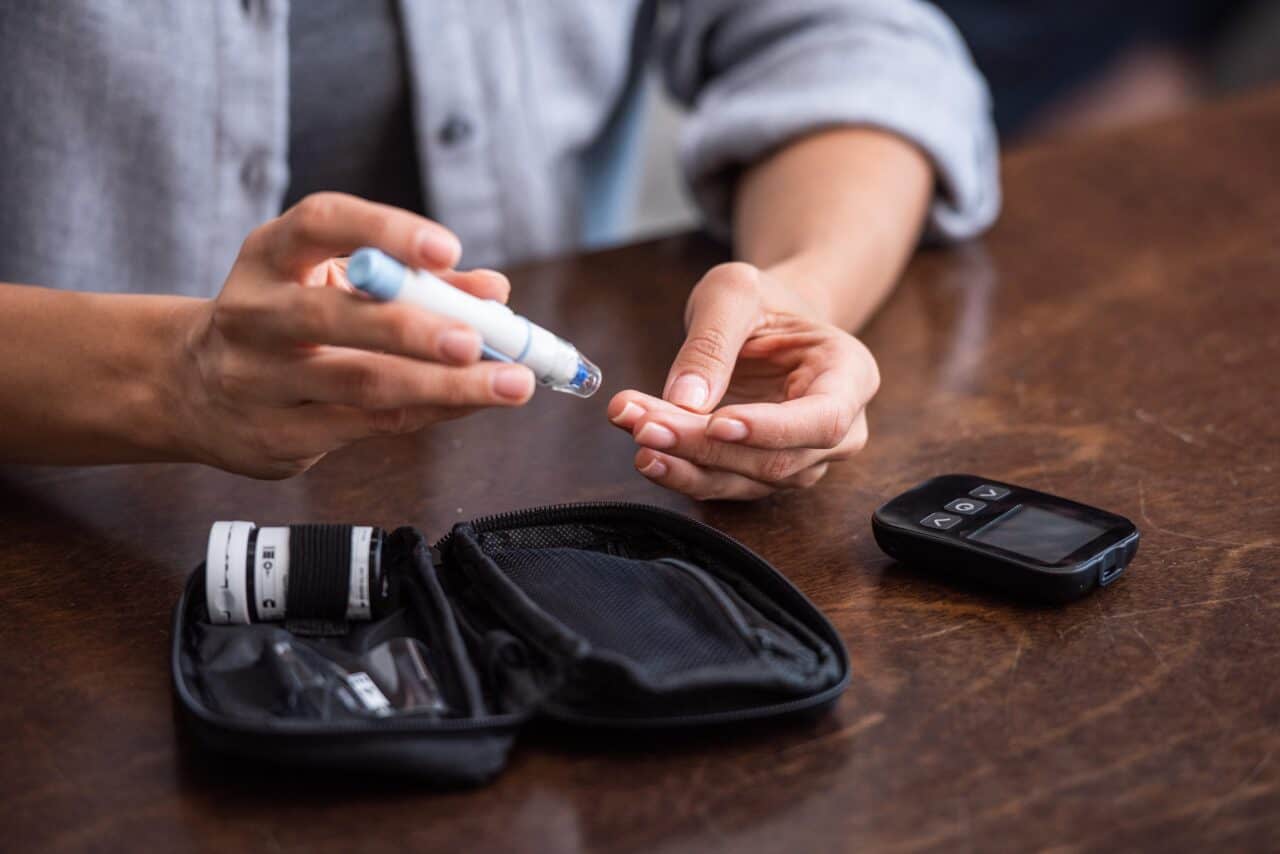 diabetes and cataract: man taking a blood sugar test