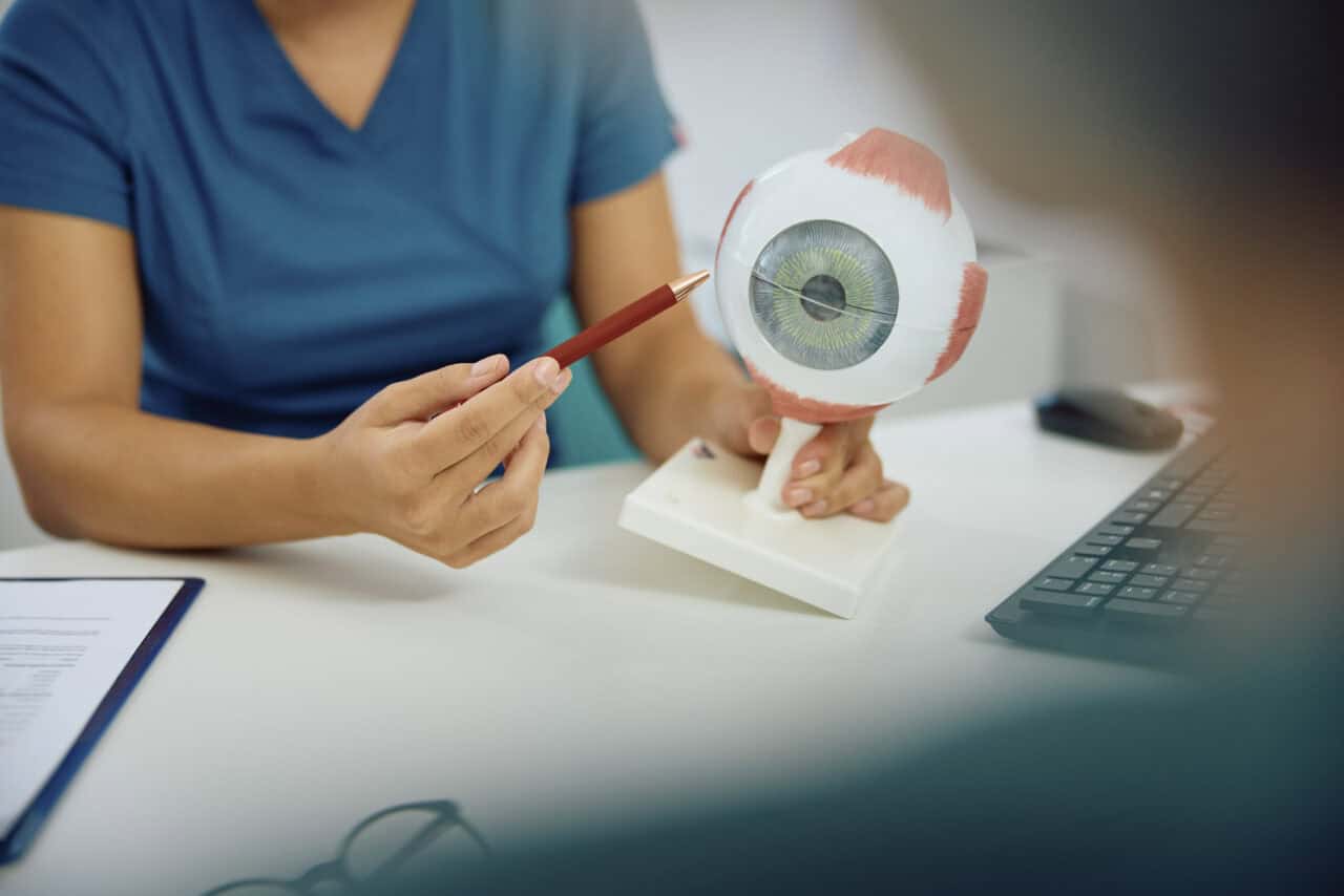 Close up of ophthalmologist using artificial oculus sample during appointment with a patient at her office.
