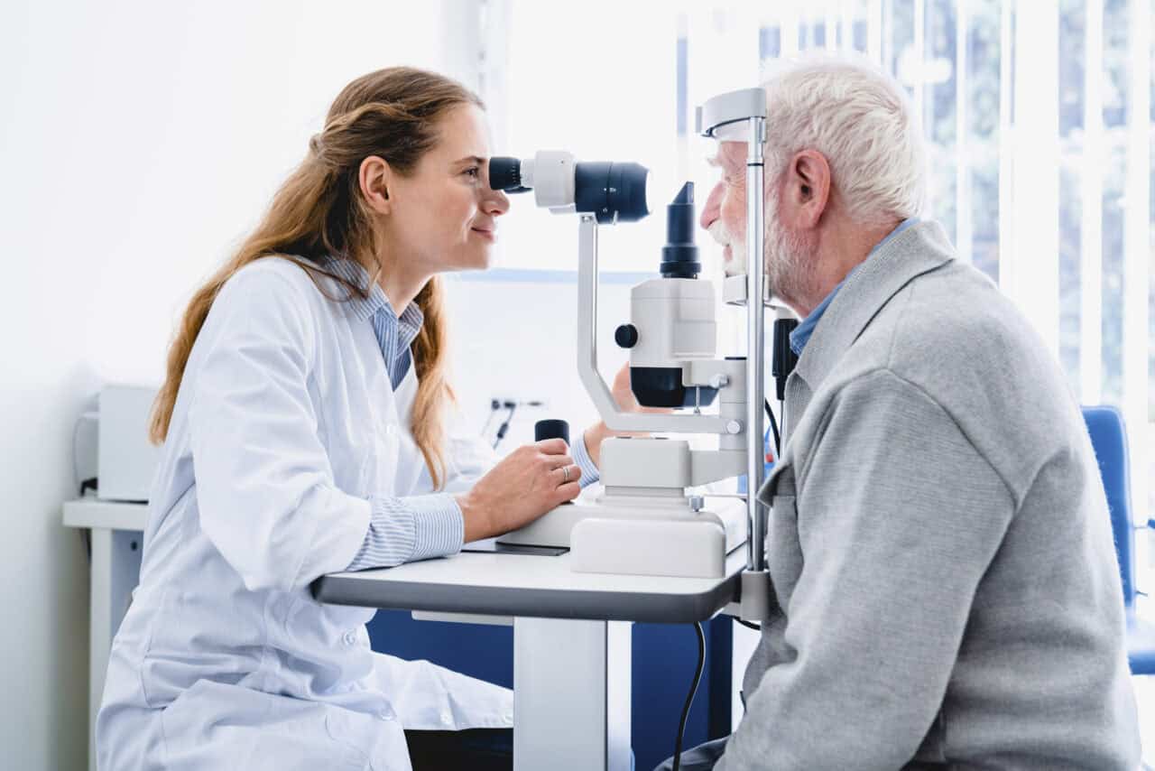 Female ophthalmologist examining mature man`s eyes